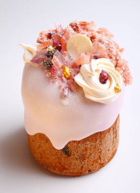 Gül sır içinde üzüm ve şekerleri ile Paskalya pastası beyaz bir arka planda fındık, moleküler bisküvi ve beze ile dekore edilmiştir.