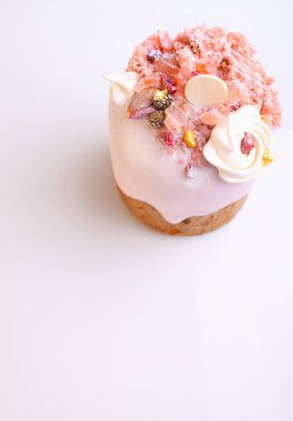 Gül sır içinde üzüm ve şekerleri ile Paskalya pastası beyaz bir arka planda fındık, moleküler bisküvi ve beze ile dekore edilmiştir.