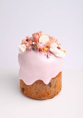 Gül sır içinde üzüm ve şekerleri ile Paskalya pastası beyaz bir arka planda fındık, moleküler bisküvi ve beze ile dekore edilmiştir.