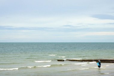 Uçsuz bucaksız denizde yürüyen bir adam.