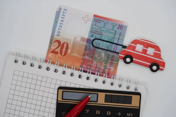 Pinkfarbene Büroklammer Form Eines Autos Taschenrechner Kugelschreiber Und Schweizer Banknoten — Stockfoto