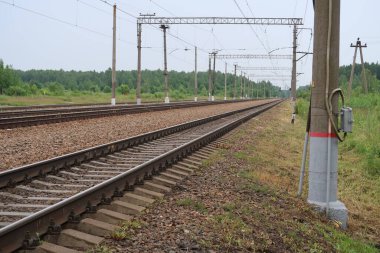 Elektrikli demiryolu rayları, demir yolları ve kutuplar, yaz mevsimi boyunca uzanıyor.