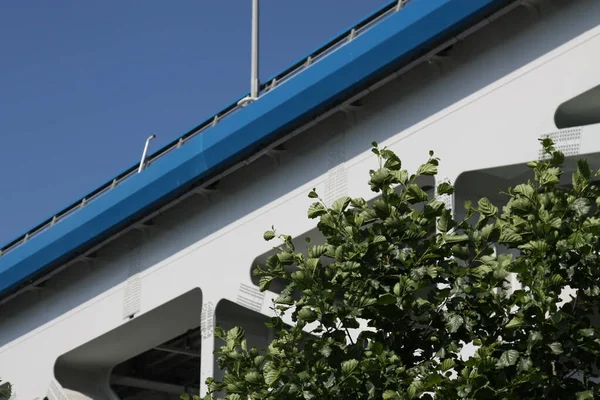 橋の金属構造物は 青い空に対して 木の葉の横に青色でトリミング — ストック写真