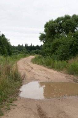 Kumlu bir köy yolunda bir su birikintisi