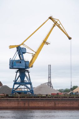 Gantry vinci bir nehir limanında çakıl yüklüyor