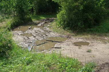  Yağmur, su birikintileri ve çamur üstüne köy yolu