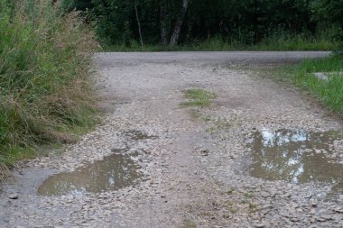 İnce çakıl yolundaki su birikintileri, yansıma