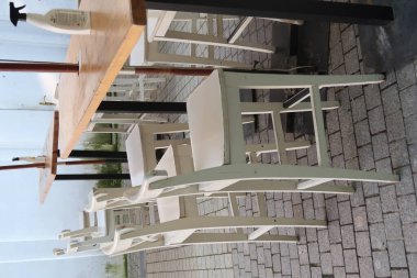 Bir kafede boş masalar, beyaz sandalyeler.