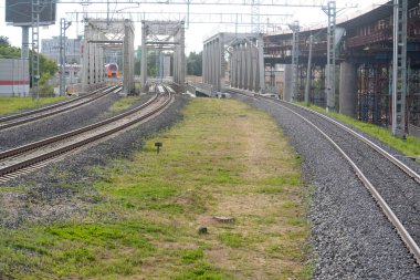  Üç paralel tren yolu, üç köprü, bir elektrikli tren ve inşaat halindeki bir üstgeçit.