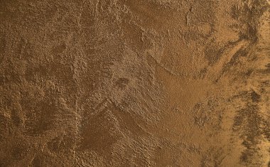 Altın pürüzlü duvar yüzeyinde, arka planda büyük boya lekeleri