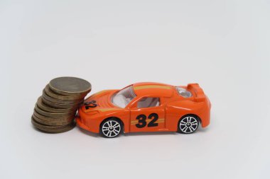 Oyuncak araba bozuk para yığınına çarptı. Otomobil sigortası sembolü.