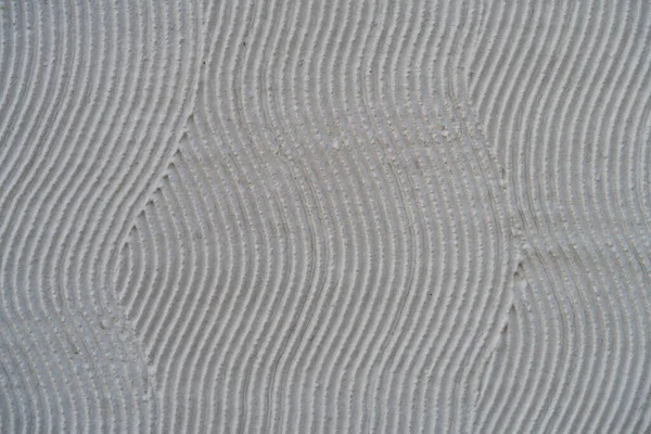 Sinuous grooves on plaster, flat surface, background