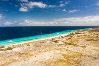 Karayip Denizi 'ndeki Klein Curacao kıyılarının turkuaz su, uçurum, plaj ve güzel mercan resifleriyle hava manzarası.