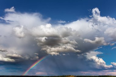 Gökyüzündeki doğal gökkuşağı ve bulutlar. Parlak, renkli arka plan sanat tasarımı.