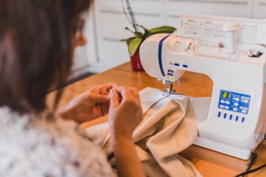 Yaşlı kadın bir dikiş makinesi ev tarafından diker