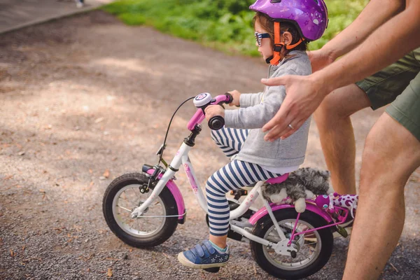 Babası Küçük Yürümeye Başlayan Çocuk Kızı Parkta Bisiklete Binmeyi Öğretir — Stok fotoğraf