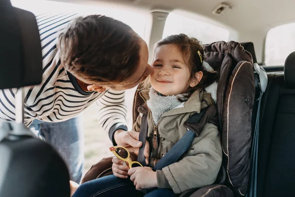 Apa megcsókolja kisgyermek lánya felcsatolta neki autósülés kabát — Stock Fotó