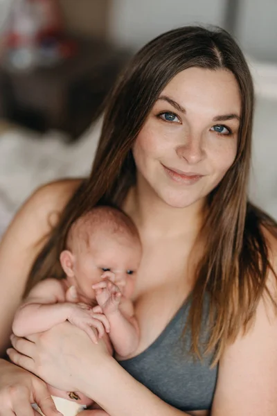 Bela jovem mãe segura suavemente bebê recém-nascido — Fotografia de Stock