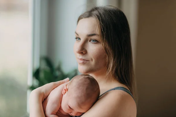 Hermosa joven madre sostiene suavemente bebé recién nacido —  Fotos de Stock