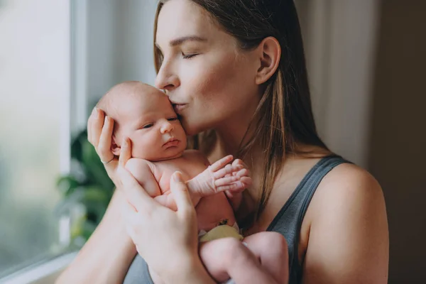 Bela jovem mãe segura suavemente bebê recém-nascido — Fotografia de Stock