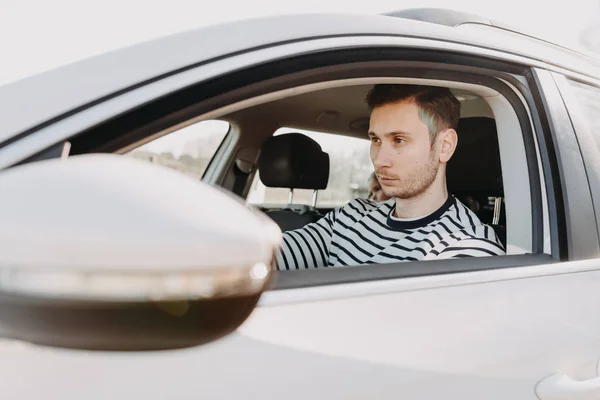 Привлекательный мужчина за рулем белой машины — стоковое фото
