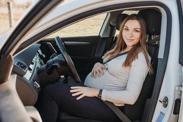 Belle jeune femme enceinte assise en voiture. Concept d'entraînement de sécurité . — Photo