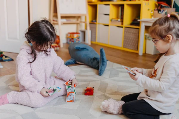 Zwei kleine Mädchen spielen im Kinderzimmer Kartenspiel für Kinder — Stockfoto