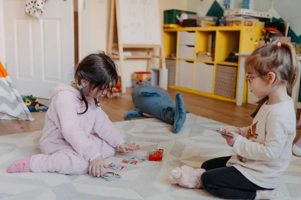 Zwei kleine Mädchen spielen im Kinderzimmer Kartenspiel für Kinder — Stockfoto