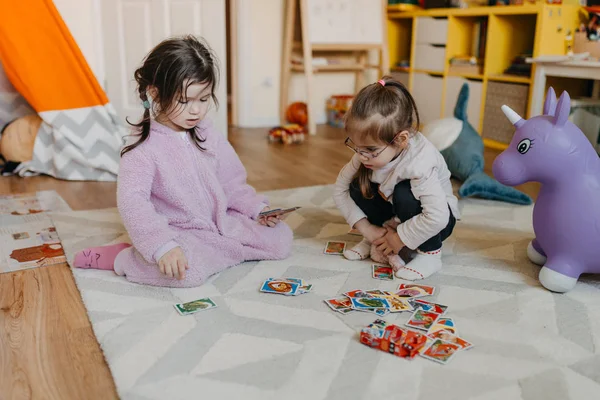 Duas meninas jogam no jogo de cartas de berçário para crianças — Fotografia de Stock