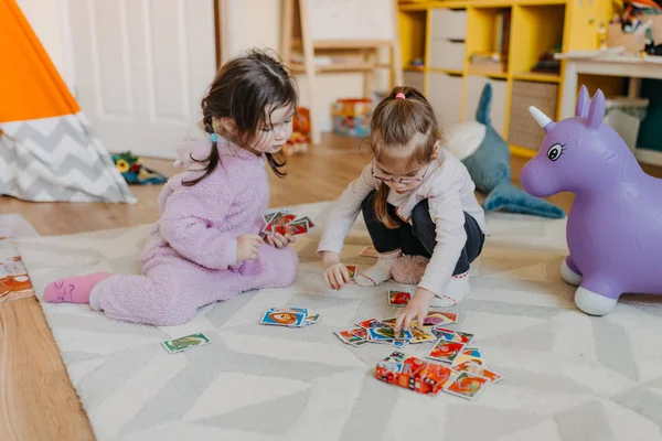 Duas meninas jogam no jogo de cartas de berçário para crianças — Fotografia de Stock