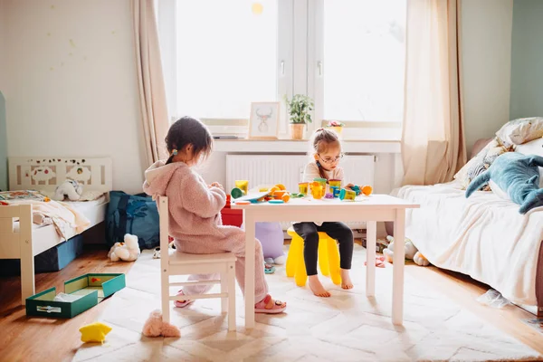 Duas meninas brincam no berçário com massa de brincar — Fotografia de Stock