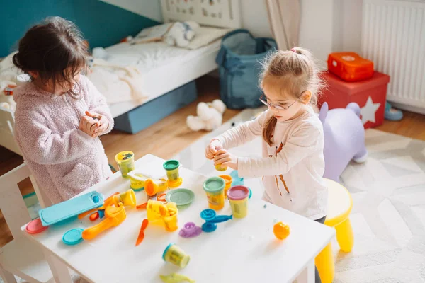 Duas meninas brincam no berçário com massa de brincar — Fotografia de Stock