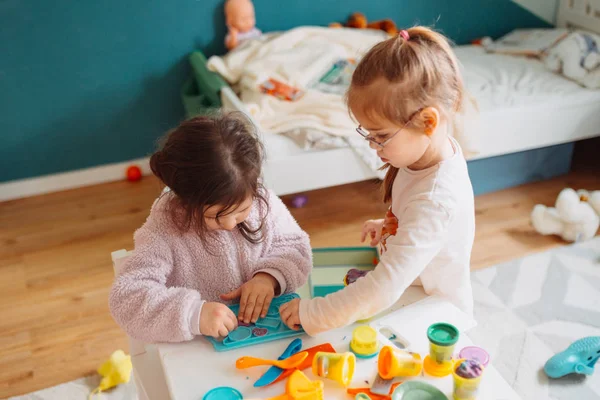 Dwie małe dziewczynki bawią się w przedszkolu z ciastem do zabawy — Zdjęcie stockowe
