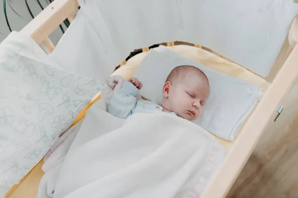 Newborn baby sleeps in the baby bed — Stock Photo, Image