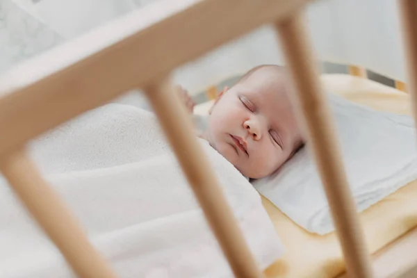 Newborn baby sleeps in the baby bed — Stock Photo, Image