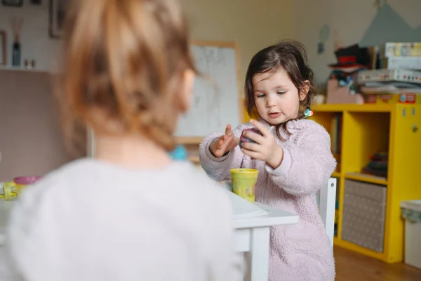 Duas meninas brincam no berçário com massa de brincar — Fotografia de Stock