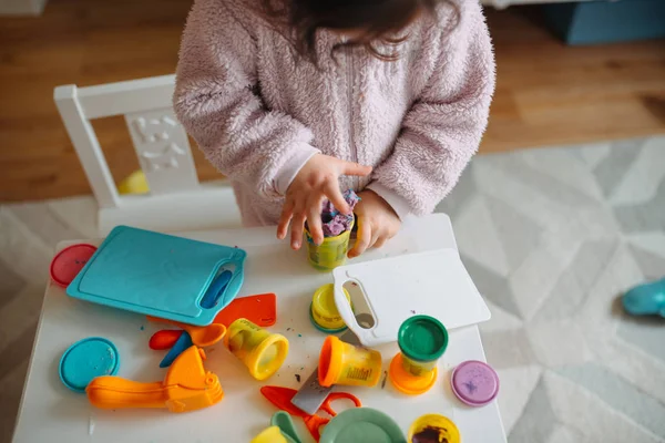 Zwei kleine Mädchen spielen im Kinderzimmer mit Spielteig lizenzfreie Stockfotos