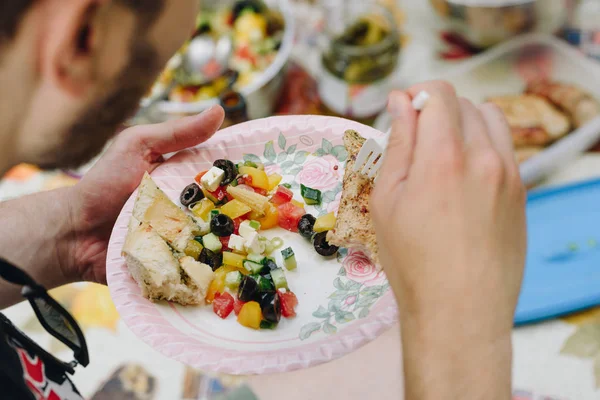 Primo piano, vista dall'alto sulle mani di mans mangiare insalata, carne alla griglia e — Foto Stock