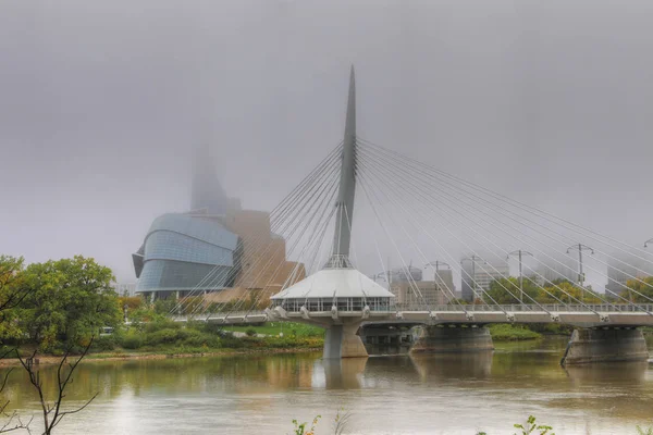 Bridge og Museum for Menneskerettigheder i tåge i Winnipeg - Stock-foto