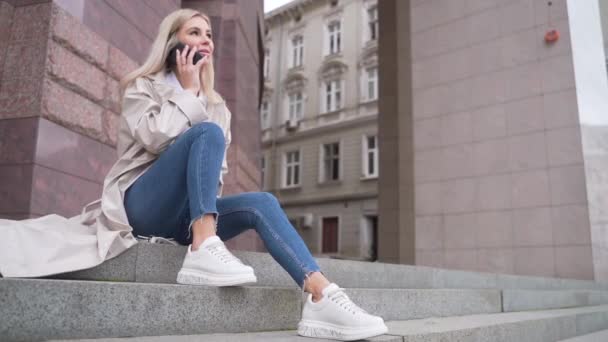 Joven Mujer Atractiva Abrigo Beige Jeans Sentados Las Escaleras Hablando — Vídeos de Stock