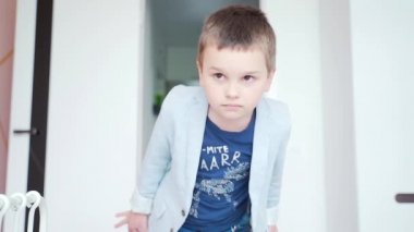 İlginç bir şekilde kameraya bakan meraklı bir çocuğun portresi. Ceketli, kotlu şık bir adam kameraya atlayıp parmağını işaret ediyor.