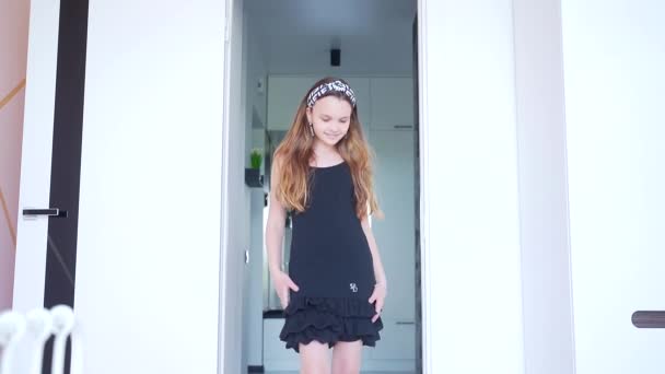 小女孩在相机前或镜子前摆姿势 或穿着黑色衣服在家里的房间里摆姿势 时尚快乐的孩子在镜头前对着时装秀笑 — 图库视频影像