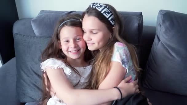 Дві Дівчинки Підлітки Обіймаються Сміються Дивані Щасливі Діти Схиляються Разом — стокове відео