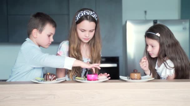 Δύο Κοριτσάκια Και Ένα Αγόρι Κάθονται Στην Κουζίνα Και Γιορτάζουν — Αρχείο Βίντεο