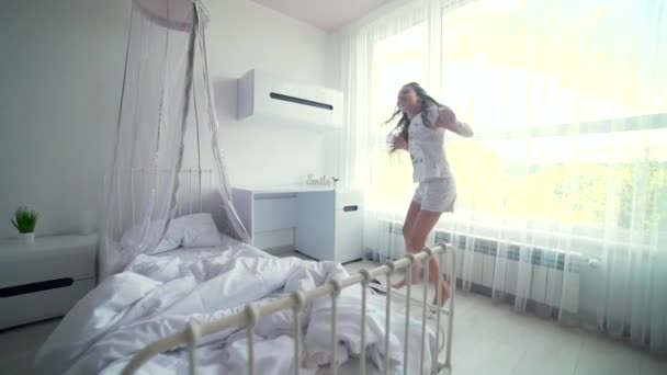 머리에 파자마를 침실에서 즐거운 시간을 보내고 귀여운 코카서스 소녀가 행복해 — 비디오