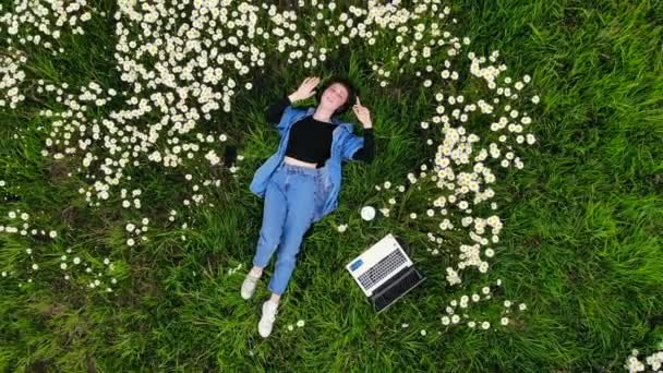 Jong Hipster Meisje Liggend Het Gazon Tussen Bloemen Luistert Naar — Stockvideo