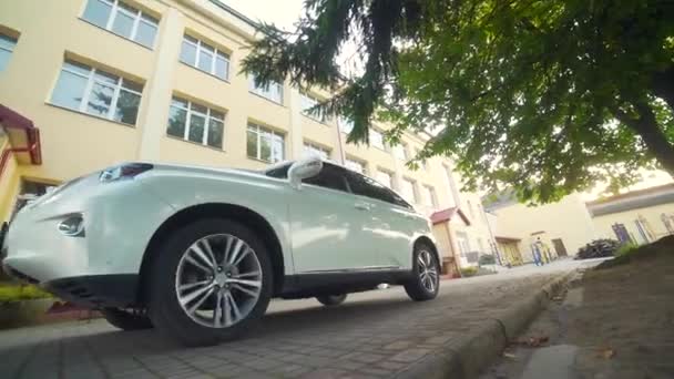 Luxe Witte Auto Rijdt Langs Het Gebouw Zijaanzicht Het Voertuig — Stockvideo