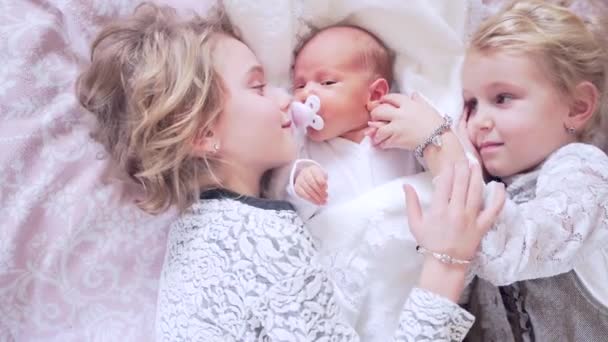 Три Милі Маленькі Діти Лежать Ліжку Сестри Обіймають Цілують Новонароджену — стокове відео
