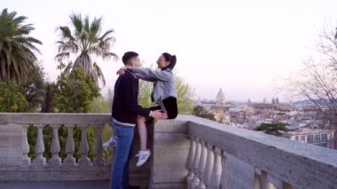 Aşık genç hippi çiftin portresi. Kız tırabzanda oturur ve sarılır.