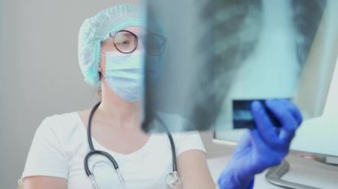 Kadın doktor, florografiyi inceliyor. Kadın pulmonolog akciğerlere bakıyor. İltihaplı bir hastanın teşhis kliniği. tomografi dolabı. Hastane ya da poliklinik röntgeni